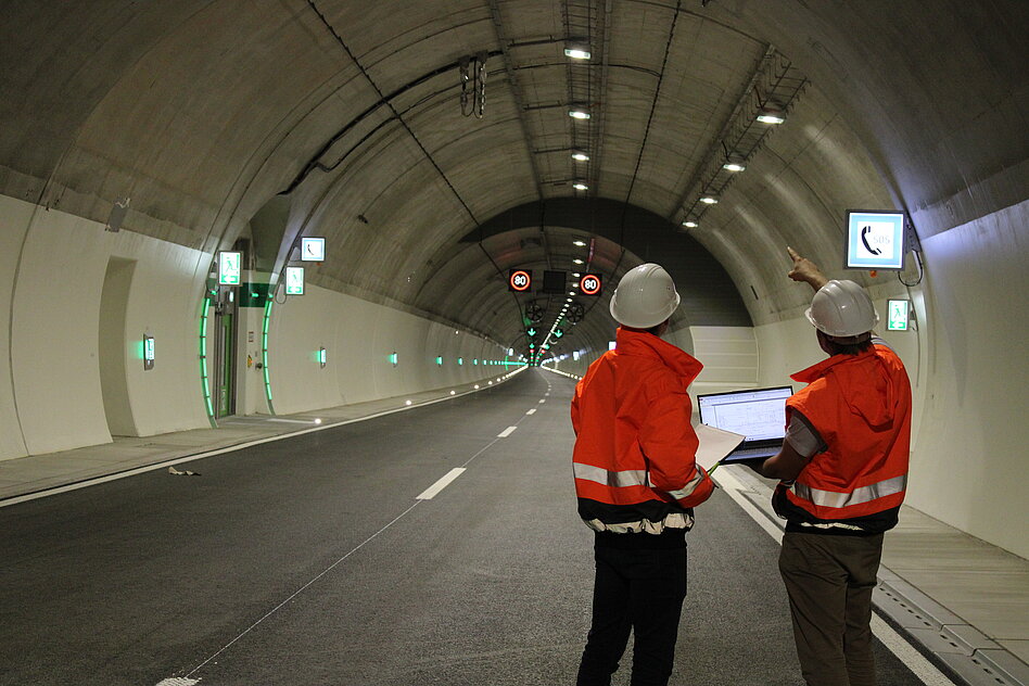 Zwei Bauleiter besprechen sich in einem Tunnel