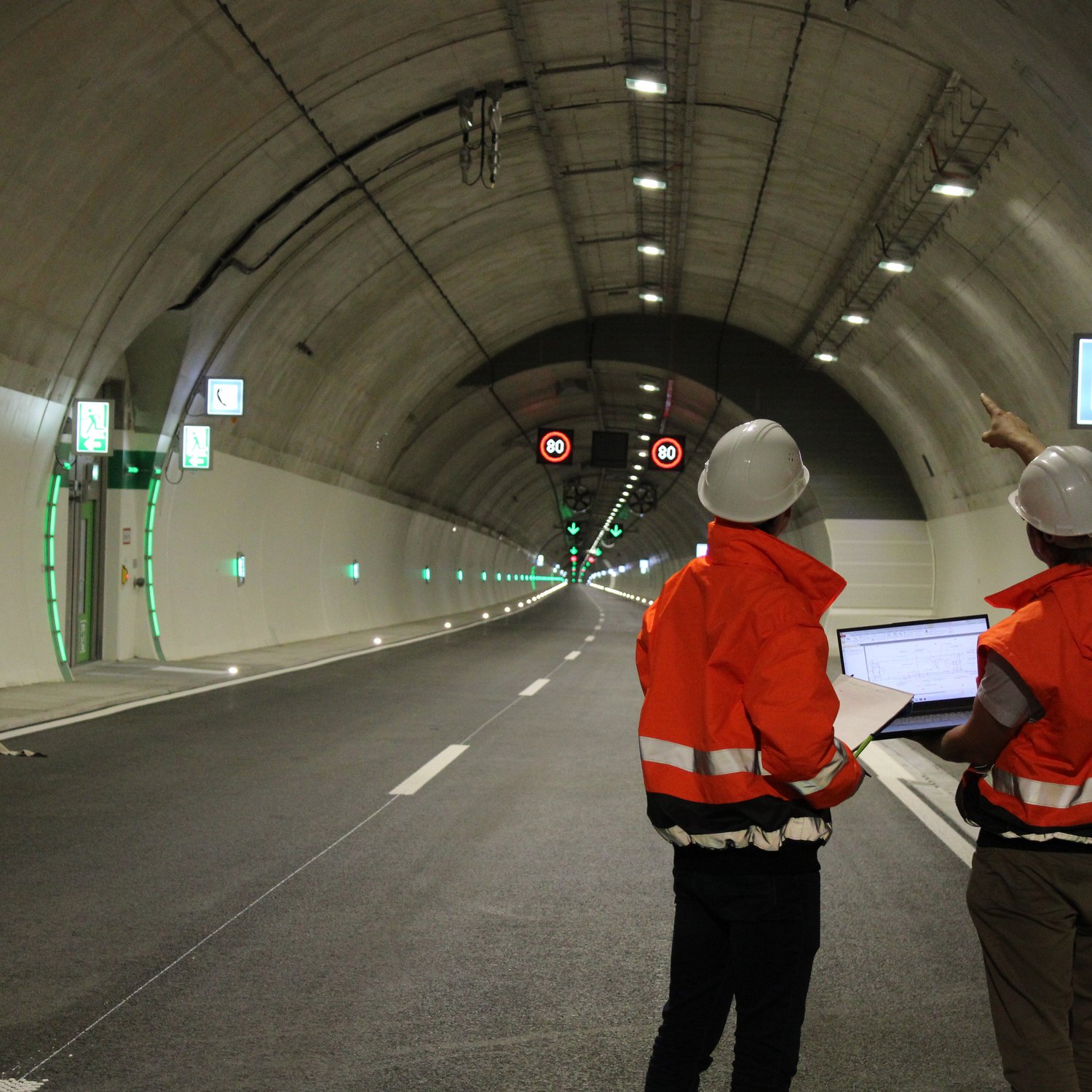 Zwei Bauleiter besprechen sich in einem Tunnel