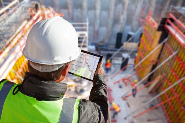 Bauleiter hält ein Tablet mit abgebildeten Statistiken in der Hand